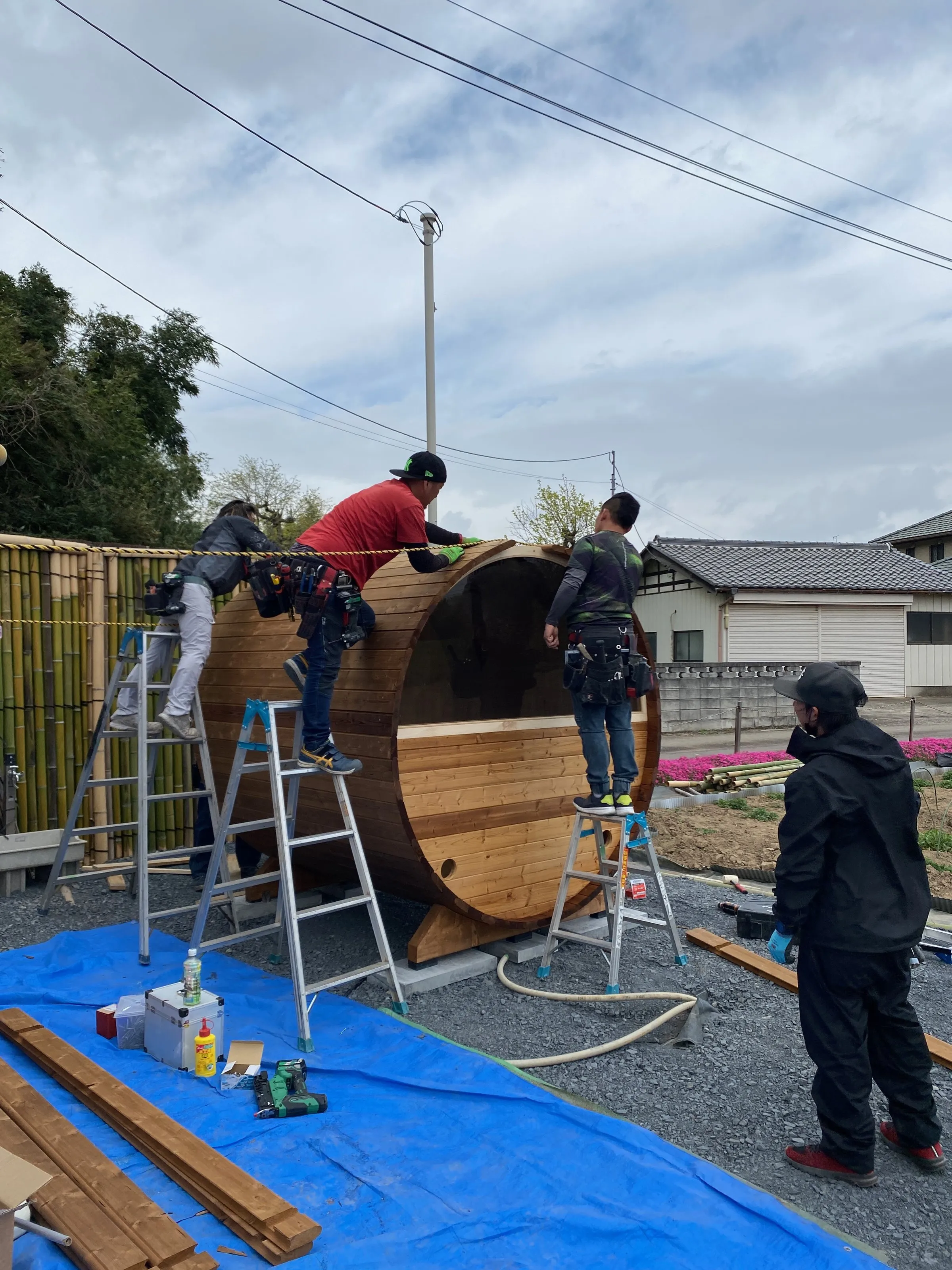The five-person assembly crew building the barrel sauna in a single day