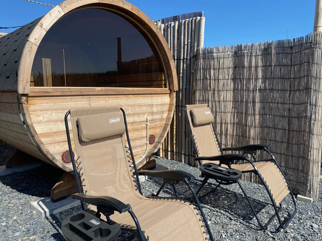 The Estonian barrel sauna outdoors, its cedar and shingled roof in good condition