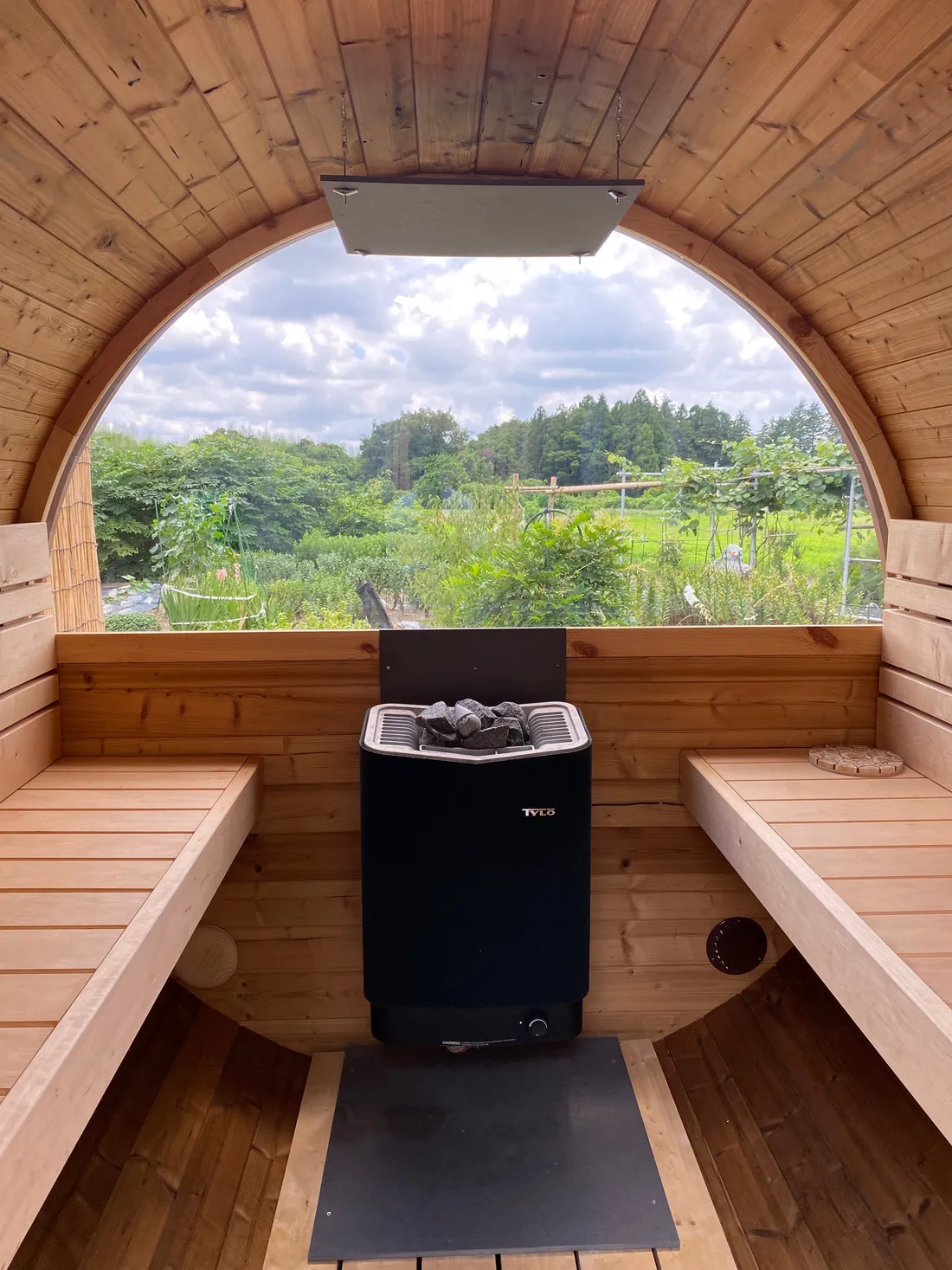 View through the barrel sauna's round window from the interior bench