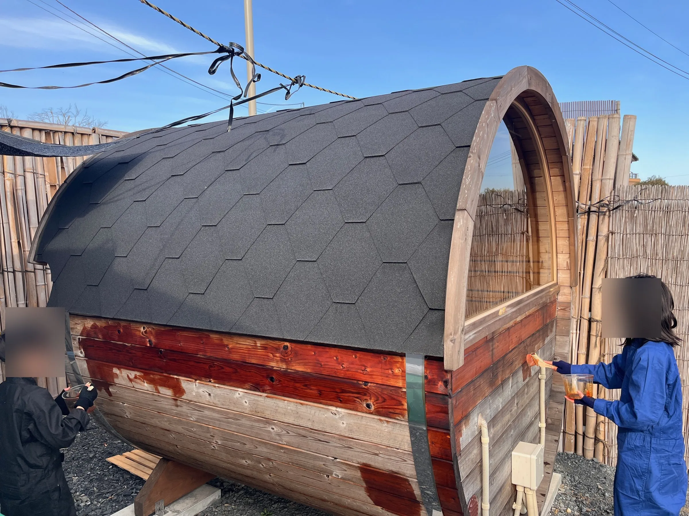 Repainting the barrel sauna together as a family