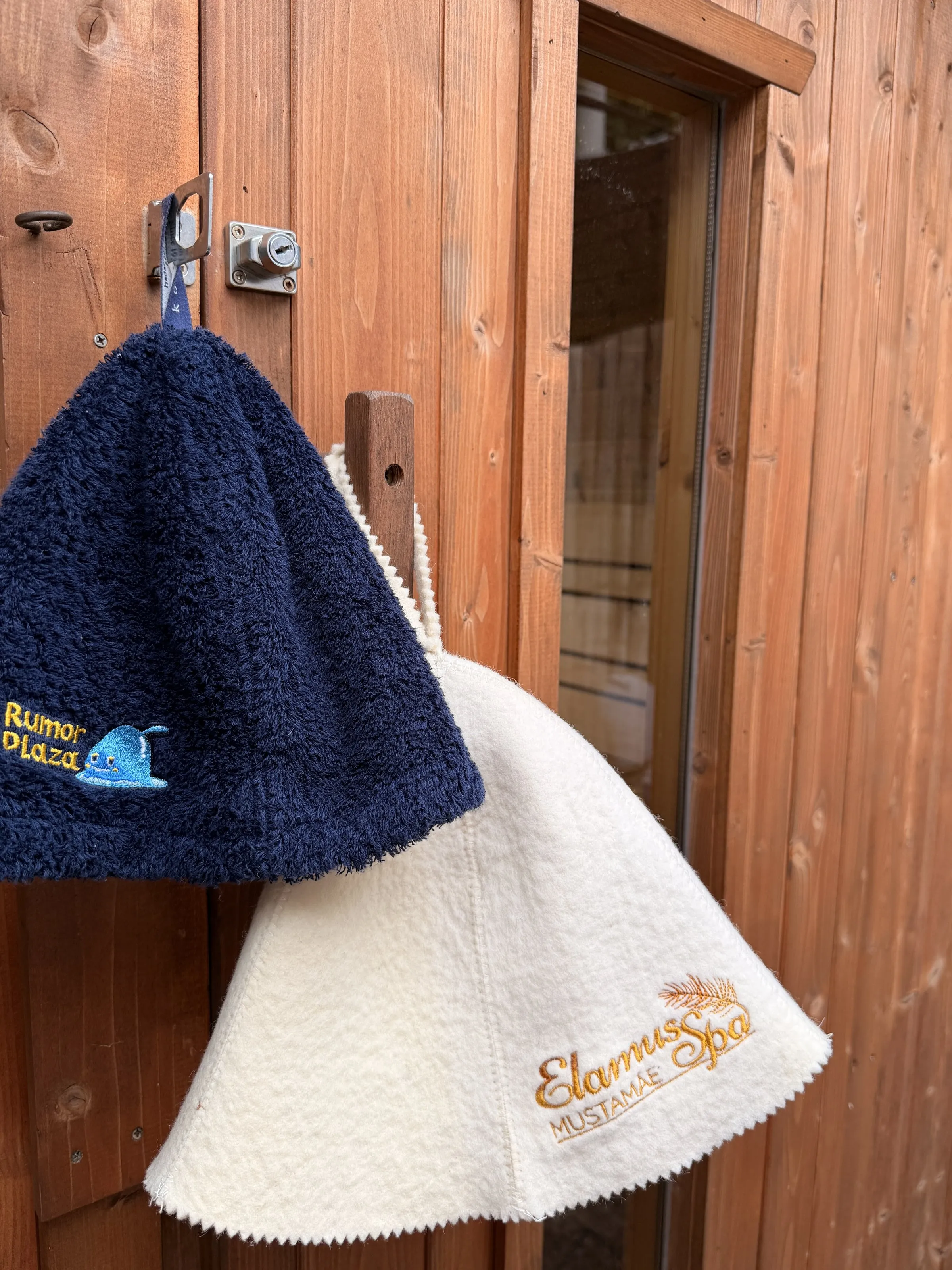 Two sauna hats hanging in the barrel — one from Elamus Spa in Estonia, one from a bathhouse in Kyoto